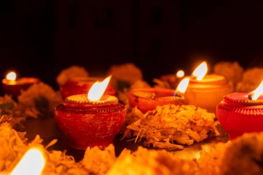 Rangoli çiçeklerinin, mumların ya da diyaların düşük açılı görüntüsü, geceleri Deepawali ışıkları. Koyu arkaplan resmi.