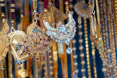 Hindistan 'da Kalighat, Kolkata, Batı Bengal' de, Hintli Bengalli kadınlara satılmak üzere uğurlu altın kaplama boyun parçaları asılıyor. Hinduizm 'de altın zenginliği simgeler. Hindu evli kadınlar bunları giyer..