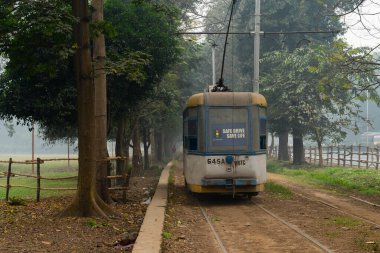 Kolkata, Batı Bengal, Hindistan - 23 Ocak 2020: Elektrik tramvayı Kolkata Maidan bölgesinden geçiyor. Hindistan 'da çalışan tek tramvay sistemi ve 100 yıllık Asya' daki en eski tramvay sistemidir..