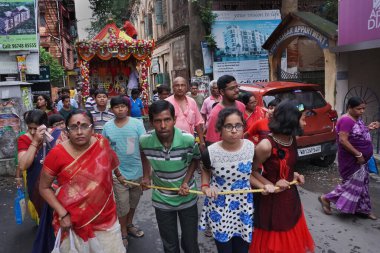HOWRAH, Batı BEST BENGAL, INDIA - 22 HAZİRAN 2018: Tanrı Jagannath, Balaram ve Tanrıça Suvadra 'nın kutsal halatını çekmek için sokaklarda sürükleyen genç Bengali Hindu dindarları.