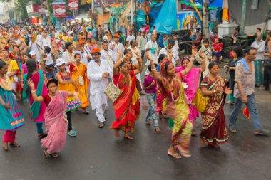 KOLKATA, Batı BENGAL, INDIA - 29 Haziran 2014: Tanrı Jagannath, Balaram ve Tanrıça Suvadra 'nın önünde dans eden kadınlar. İkon Rath Jatra Festivali.