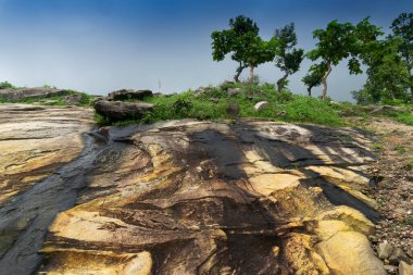 Mayur Paharh Purulia 'nın küçük bir tepesidir. Yağmur suyu tepeden aşağıya doğru sarı kayaların arasından akar ve üzerlerinde soyut paketler bırakır. Batı Bengal, Hindistan 'ın muson mevsimi.