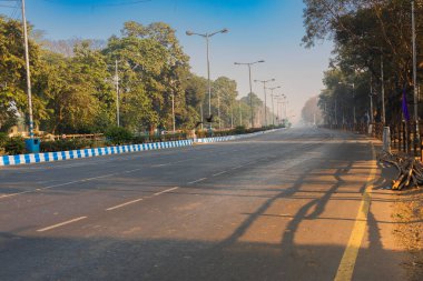Yukarıda mavi gökyüzü olan boş Kırmızı Yol 'un sabahki görüntüsü. Görüntü: Kolkata, Batı Bengal, Hindistan.