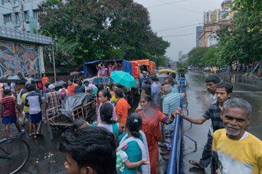 KOLKATA, Batı BENGAL, INDIA - 25 Haziran 2017: Tanrı Jagannath, Balaram ve Tanrıça Suvadra 'nın ritüeli olarak Rath (at arabası) etrafında yağmura tutulmuş dindarlar. İkon Rath Jatra Festivali.