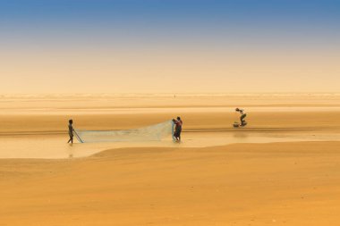 TAJPUR, Batı BEST BENGAL, INDIA - 22 Haziran 2014: Bengal Körfezi kıyılarında eşi ve oğluyla balık tutan bir balıkçı. Balıkçılık, Tajpur 'daki birçok kişi için geçim kaynağıdır..