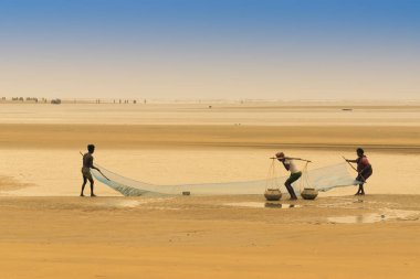 TAJPUR, Batı BEST BENGAL, INDIA - 22 Haziran 2014: Bengal Körfezi kıyılarında eşi ve oğluyla balık tutan bir balıkçı. Balıkçılık, Tajpur 'daki birçok kişi için geçim kaynağıdır..