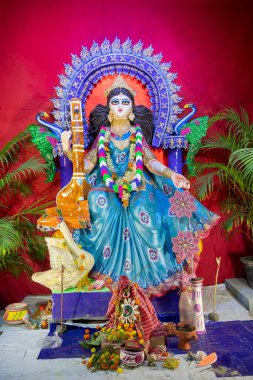 Idol of Goddess Saraswati with veena, a musical instrument and white swan, a sacred bird, at Kolkata, West Bengal, India. Saraswati is Hindu goddess of knowledge, music, art, wisdom, and learning. clipart