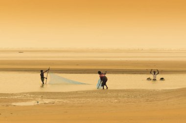 TAJPUR, Batı BEST BENGAL, INDIA - 22 Haziran 2014: Bengal Körfezi kıyılarında eşi ve oğluyla balık tutan bir balıkçı. Balıkçılık, Tajpur 'daki birçok kişi için geçim kaynağıdır..