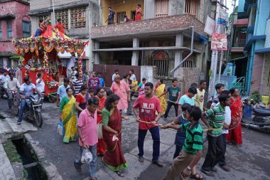 HOWRAH, Batı BEST BENGAL, INDIA - 22 HAZİRAN 2018: Tanrı Jagannath, Balaram ve Tanrıça Suvadra 'nın kutsal halatını çekmek için sokaklarda sürükleyen genç Bengali Hindu dindarları.