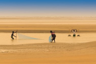 TAJPUR, Batı BEST BENGAL, INDIA - 22 Haziran 2014: Bengal Körfezi kıyılarında eşi ve oğluyla balık tutan bir balıkçı. Balıkçılık, Tajpur 'daki birçok kişi için geçim kaynağıdır..