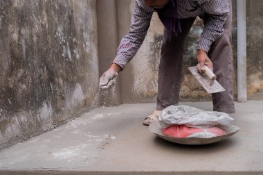 Howrah, Batı Bengal, Hindistan - 6 Ocak 2020: Hindistan işgücü düz mala kullanarak alçılı zemini düzleştiriyor ve elle beton dağıtıyor, Stock imajı.