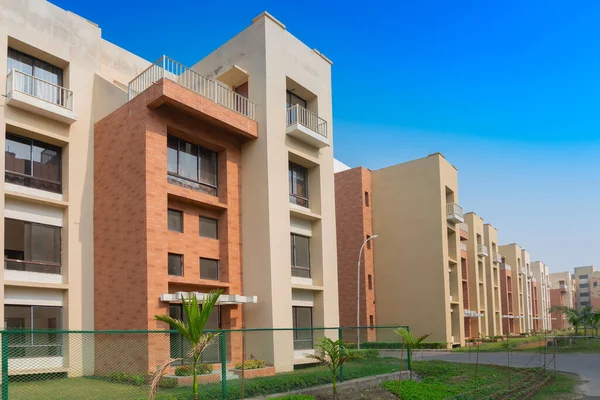 New residential building complex being built at Rajarhat New Town area of Kolkata, West Bengal, India. Kolkata is one of the fastest growing cities in eastern region of India. Blue sky background.