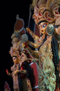 Durga Puja Pandalı 'ndaki Durga ve Laxmi putunun bulanık görüntüsü, Durga Puja festivali. Howrah, West Bengal, Hindistan 'da renkli ışığın altında çekildi..