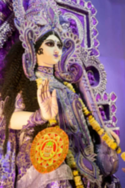 Bluured image of blessful hand of clay Idol of Goddess Saraswati at Kolkata, West Bengal, India. Saraswati is Hindu goddess of knowledge, music, art, wisdom, and learning.