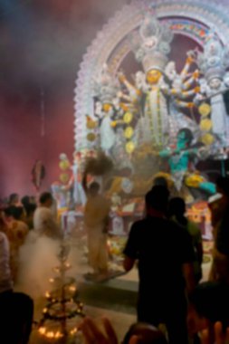 Durga Puja pandalının içinde kutsal lamba ve kutsal dumanla, renkli ışığa vurulan Tanrıça Durga putunun bulanık görüntüsü. Hinduizm 'in en büyük festivali. Kolkata, Hindistan.