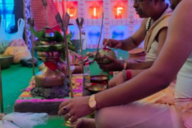 Durga Puja döneminde Durga Puja pandalında tanrıça Durga 'ya taptıkları için hindistancevizlerinin üzerine OM yazan genç Hindu Bengalli rahiplerin bulanık görüntüsü. Merhaba, Hindistan..