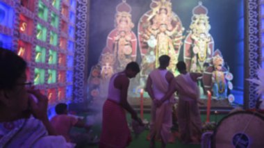 Hindu Bengalli kadının Sondhya Aarti sırasında shankha, deniz kabuğu oynarken bulanık görüntüsü. Dhaaks ve kansor ghonta tanrıça Durga 'ya tapmak için oynanır. Howrah, Batı Bengal, Hindistan.