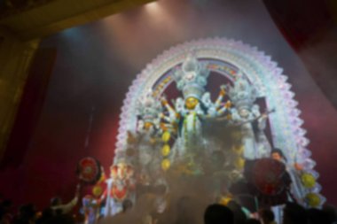 Tanrıça Durga 'ya sunulan dumanın bulanık görüntüsü ve renkli ışıkta vurulan Durga Puja pandalının içinde ibadet edilişi. Hinduizm 'in en büyük festivali. Kolkata, Hindistan.
