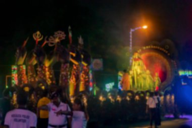 Kırmızı yoldaki Durga Puja Karnavalı 'nın bulanık görüntüsü, Durga Puja festivalinin son günlerinde tüm ünlü Durga putları birer birer yol kenarında toplanıyor..