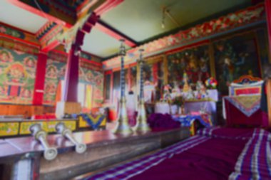 Blurred image of Rinchenpong, Sikkim, India. Musical instruments stored in the prayer room, in the prayer room of Rinchenpong monastery with decorated murals on the walls.