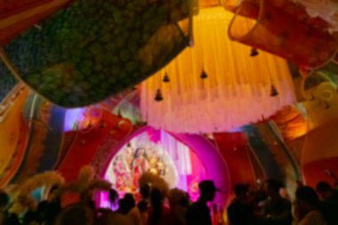 Blurred image of image of decorated Durga Puja pandal, shot at colored light at night. Durga Puja is biggest religious festival of Hinduism, celebrated all over the world. Kolkata, India.