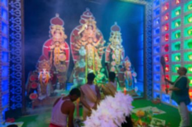 Durga Puja festivali sırasında Durga Puja pandalının içinde Durga aarti, ayna ile tanrıça Durga 'ya tapan Hindu Bengalli rahiplerin bulanık görüntüsü.