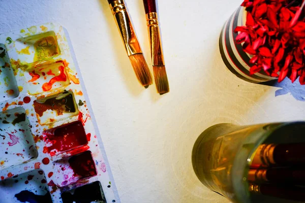 一个有水彩画板 水杯和鲜花的水彩画写字台 调色板上使用的鲜艳的颜色 在印度西孟加拉邦Howrah被枪杀 — 图库照片