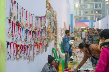Kolkata, Batı Bengal, Hindistan - 31 Aralık 2018: Hintli kadınlar renkli el yapımı mücevherleri, satılık el sanatları seçiyorlar. Hint el sanatları renkleriyle ünlüdür ve yaygın olarak kullanılır..