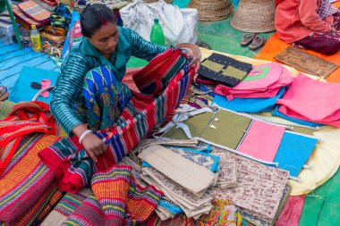 Kolkata, Batı Bengal, Hindistan - 31 Aralık 2018: Kolkata 'da halı, kapı paspası, el işi ürünleri satan genç Bengalli kadın.