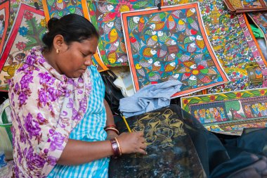 Kolkata, Batı Bengal, Hindistan - 31 Aralık 2018: Genç Bengalli kadın ressam balık, Pattachitra veya Patachitra - geleneksel kumaş tabanlı parşömen resmi. El sanatları fuarında satılık..