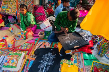 Kolkata, Batı Bengal, Hindistan - 31 Aralık 2018: Genç Bengalli kadın ve erkek sanatçılar Pattachitra veya Patachitra 'yı resmediyorlar - geleneksel, kumaş tabanlı parşömen resmi. El sanatları fuarında satılık..