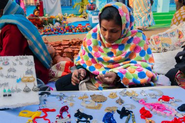 Kolkata, Batı Bengal, Hindistan - 31 Aralık 2018: Kolkata El Sanatları Fuarı sırasında çeşitli şekillerde ve tonlarda kolye satan kadın.