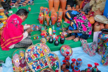 Kolkata, Batı Bengal, Hindistan - 31 Aralık 2018: Hintli evli çift, karı-koca, her ikisi de satılık renkli terasotta tencereleri boyayan sanatçılar. Kolkata El Sanatları Fuarı.