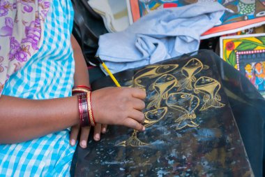 Genç Bengalli kadın ressam balık resimleri, Pattachitra ya da Patachitra - geleneksel kumaş tabanlı parşömen resimleri. El sanatları fuarında satılık..