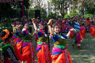 Kolkata, Hindistan - 21 Mart 2019: Sari giymiş kız dansçılar, Palash çiçekli geleneksel Hint elbisesi, Butea monosperma, makyaj, Holi festivalinde dans. Hindistan 'a Bahar geliyor..