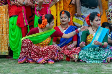 Kolkata, Hindistan - 21 Mart 2019: Sari giymiş genç bayan dansçılar, geleneksel Hint elbisesi ve Palash çiçekleri, Butea monosperma makyajı, Holi festivalinde danstan önce sohbet.