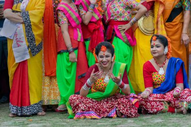 Kolkata, Hindistan - 21 Mart 2019: Sari giymiş genç bayan dansçı, Palash çiçekli geleneksel Hint elbisesi, Butea monosperma makyaj, Bahar geldiğinde Holi festivalinde kahkahalar.