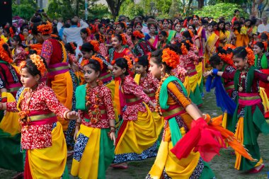 Kolkata, Hindistan - 21 Mart 2019: Renkli sari (geleneksel Hint elbisesi) ve Palash çiçekleri (Butea monosperma) giymiş kız dansçılar, Dol (Bengalce) veya Holi (Hintçe) festivalinde dans ediyorlar..
