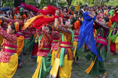 Kolkata, Hindistan - 21 Mart 2019: Sari giymiş kız dansçılar, Palash çiçekli geleneksel Hint elbisesi, Butea monosperma, makyaj, Holi festivalinde dans. Hindistan 'a Bahar geliyor..
