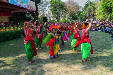 Kolkata, Hindistan - 21 Mart 2019: Sari giymiş kız dansçılar, Palash çiçekli geleneksel Hint elbisesi, Butea monosperma, makyaj, Holi festivalinde dans. Hindistan 'a Bahar geliyor..