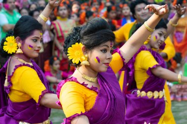 Kolkata, Hindistan - 21 Mart 2019: Sari giymiş kız dansçılar, Palash çiçekli geleneksel Hint elbisesi, Butea monosperma, makyaj, Holi festivalinde dans. Hindistan 'a Bahar geliyor..
