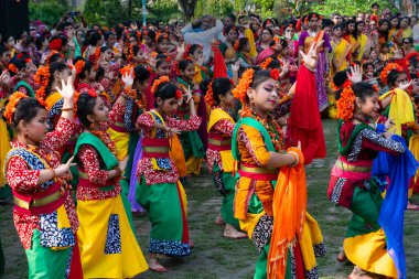 Kolkata, Hindistan - 21 Mart 2019: Renkli sari (geleneksel Hint elbisesi) ve Palash çiçekleri (Butea monosperma) giymiş kız dansçılar, Dol (Bengalce) veya Holi (Hintçe) festivalinde dans ediyorlar..