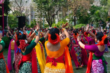 Kolkata, Hindistan - 21 Mart 2019: Sari giymiş kız dansçılar, Palash çiçekli geleneksel Hint elbisesi, Butea monosperma, makyaj, Holi festivalinde dans. Hindistan 'a Bahar geliyor..
