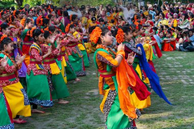 Kolkata, Hindistan - 21 Mart 2019: Sari giymiş kız dansçılar, Palash çiçekli geleneksel Hint elbisesi, Butea monosperma, makyaj, Holi festivalinde dans. Hindistan 'a Bahar geliyor..