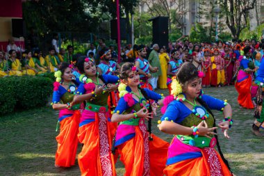 Kolkata, Hindistan - 21 Mart 2019: Sari giymiş kız dansçılar, Palash çiçekli geleneksel Hint elbisesi, Butea monosperma, makyaj, Holi festivalinde dans. Hindistan 'a Bahar geliyor..
