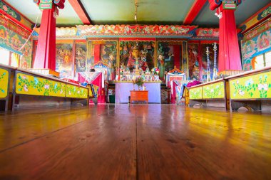 Rinchenpong, Sikkim, Hindistan - 17 Ekim 2016: Budizm 'in dinsel heykelleri Rinchenpong manastırındaki ahşap zemine yansıyor ve duvarlarında süslü duvar resimleri var. Yer seviyesinden görüntü görüntüsü.