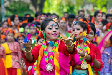 Kolkata, Hindistan - 21 Mart 2019: Renkli sari (geleneksel Hint elbisesi) ve Palash çiçekleri (Butea monosperma) giymiş kız dansçılar, Dol (Bengalce) veya Holi (Hintçe) festivalinde dans ediyorlar..