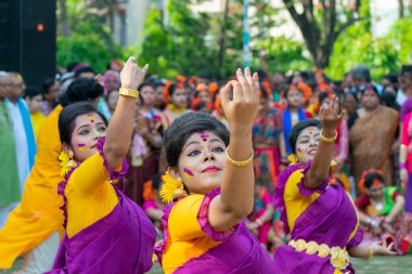 Kolkata, Hindistan - 21 Mart 2019: Renkli sari (geleneksel Hint elbisesi) ve Palash çiçekleri (Butea monosperma) giymiş kız dansçılar, Dol (Bengalce) veya Holi (Hintçe) festivalinde dans ediyorlar..