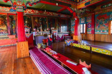 Rinchenpong, Sikkim, Hindistan - 17 Ekim 2016: Genç bir çocuk Lama Rinchenpong manastırının içinde duruyor çatısı ve duvarları süslenmiş duvar resimleriyle. Aşağıdan ateş edilmiş..