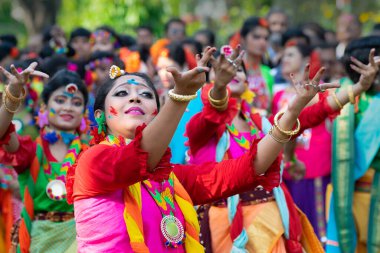 Kolkata, Hindistan - 21 Mart 2019: Renkli sari (geleneksel Hint elbisesi) ve Palash çiçekleri (Butea monosperma) giymiş kız dansçılar, Dol (Bengalce) veya Holi (Hintçe) festivalinde dans ediyorlar..